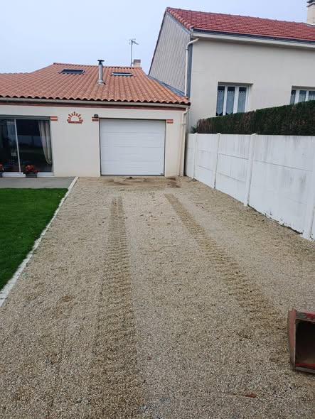 Allée empierrée menant au garage, traces de la mini-pelle encore visibles