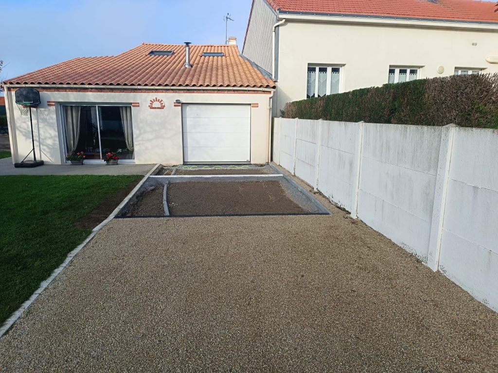 Allée en gravillons terminée devant le garage, avec bordures posées
