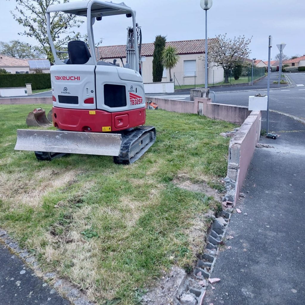 Mini-pelle Takeuchi sur une pelouse avant la création d'un parking