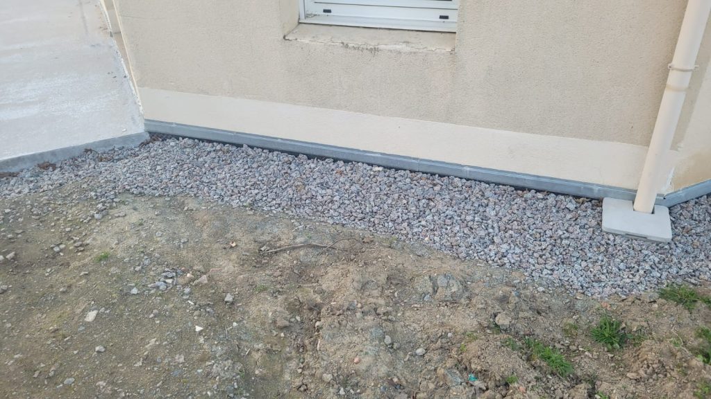 Drainage terminé et recouvert de gravillons le long de la maison, à Beaurepaire