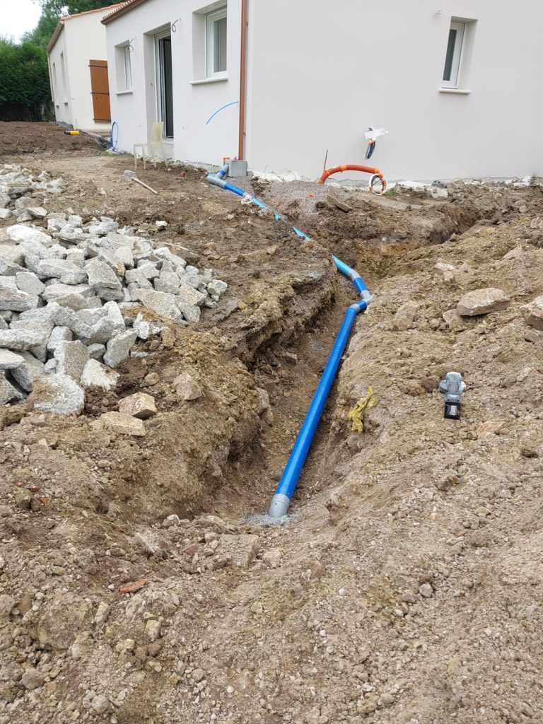 Canalisation d'évacuation posée en tranchée vers la fosse, près d'une maison neuve