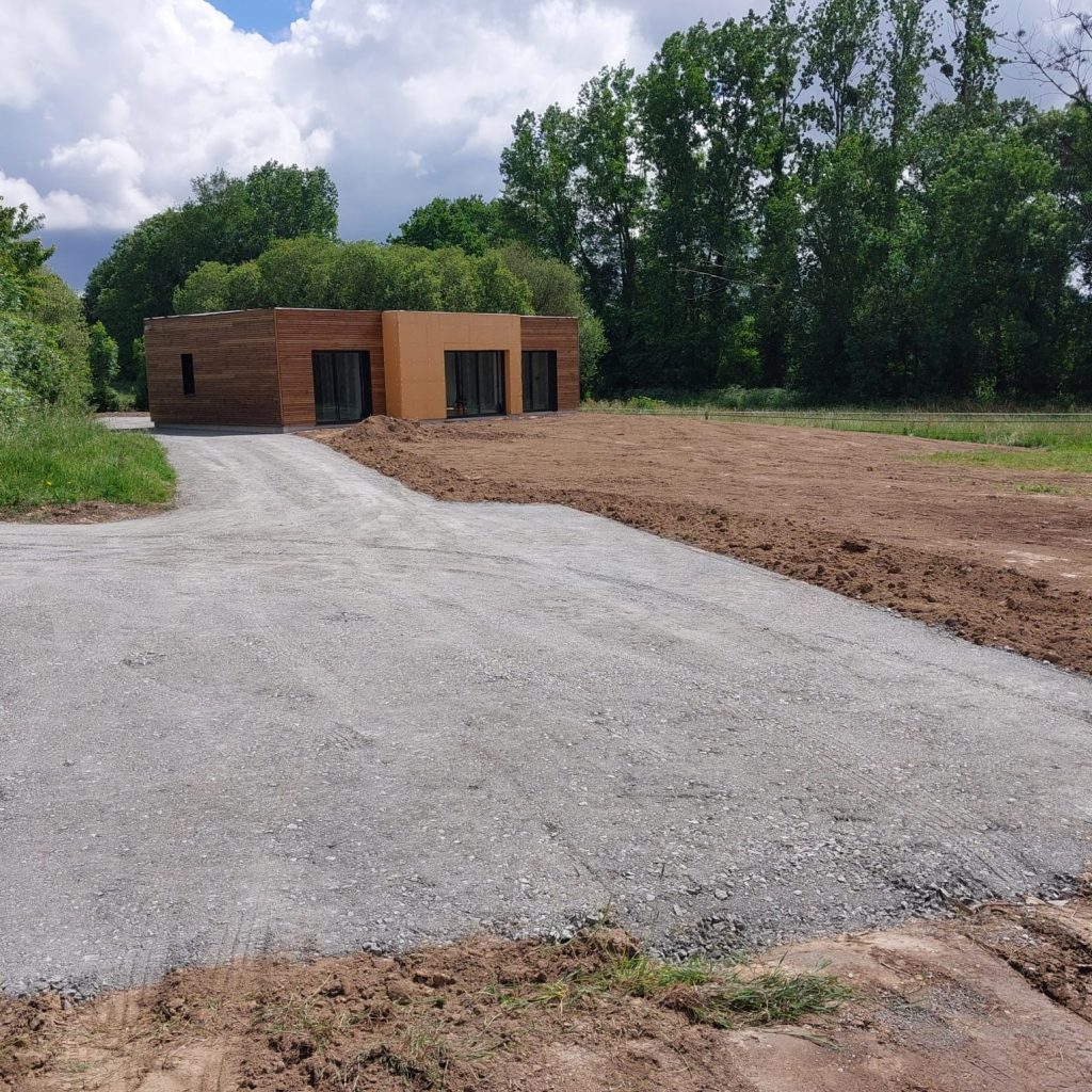 Accès empierré créé jusqu'à une maison neuve à bardage bois
