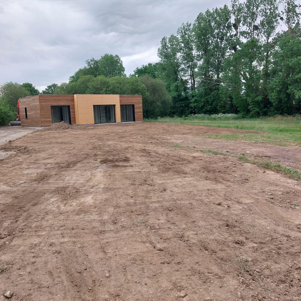 Terrain décapé devant une maison à bardage bois, avant la création de l'accès